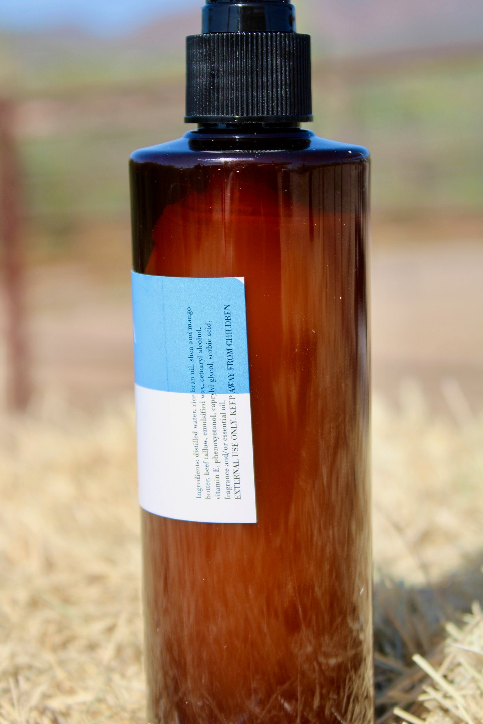 Brown bottle with a label on a blurred natural background